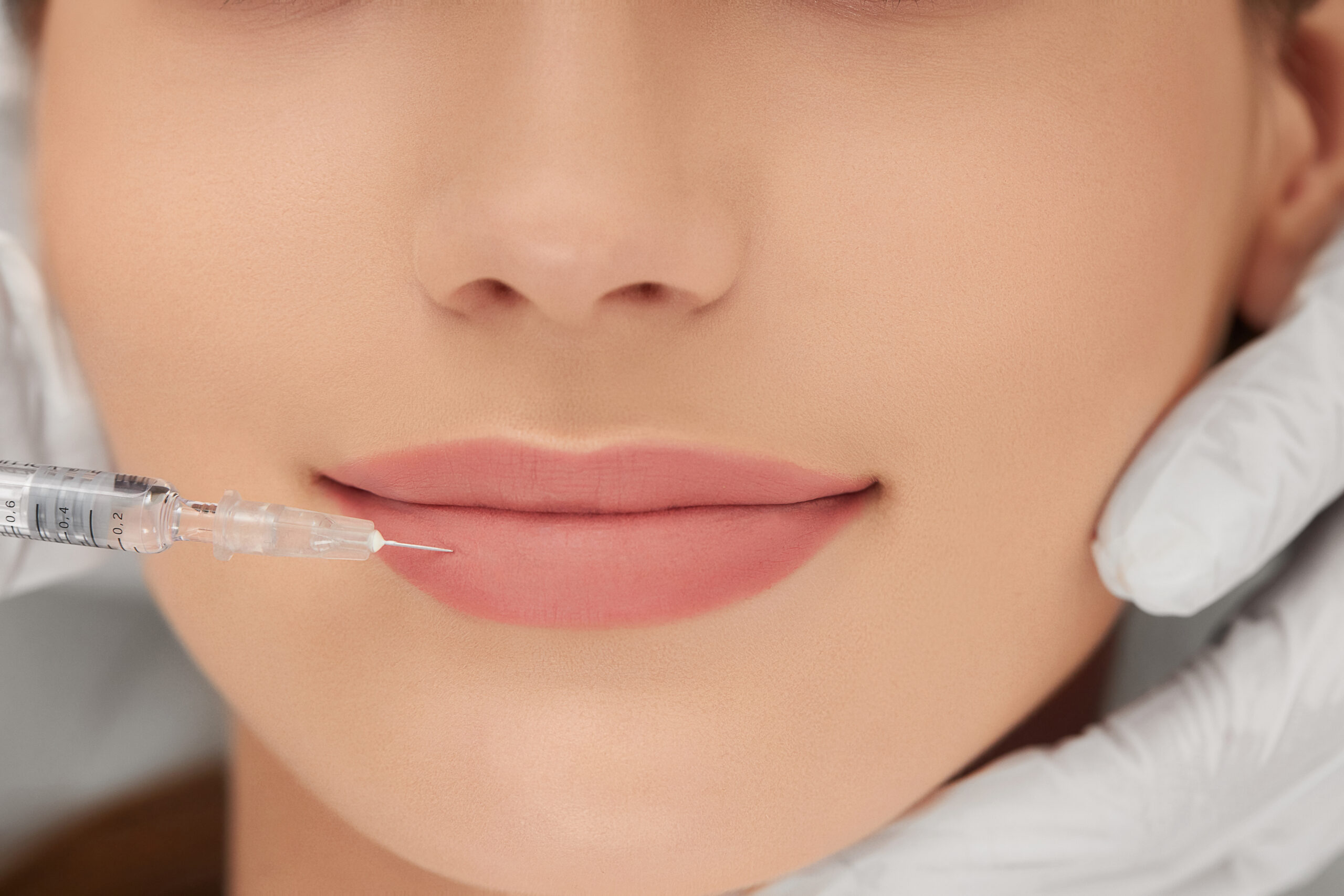 Beautician doing procedure for lip augmentation.