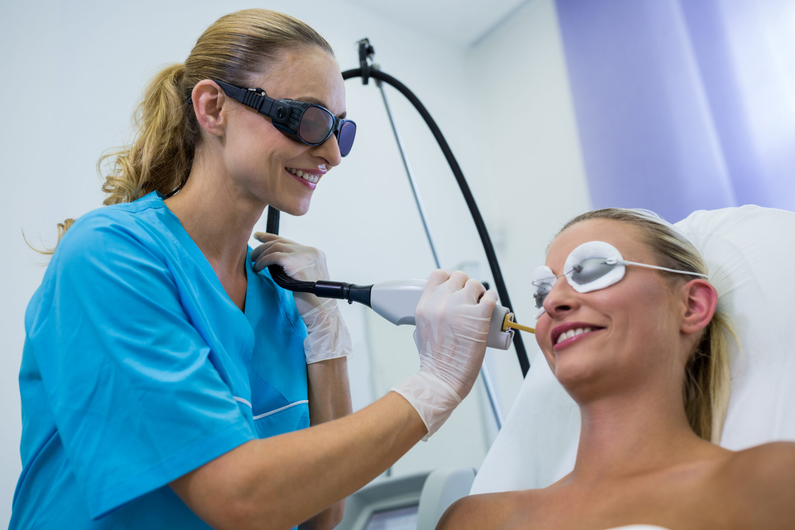 Woman receiving laser epilation treatment on her face at beauty salon