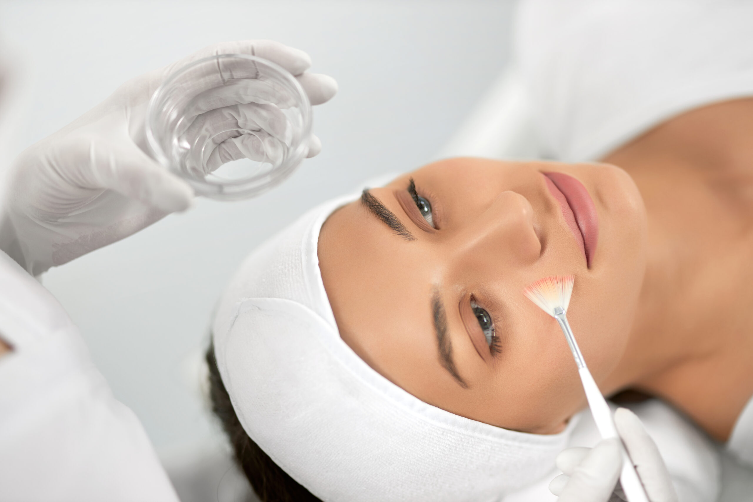 Young woman doing procedure for face in beautician.